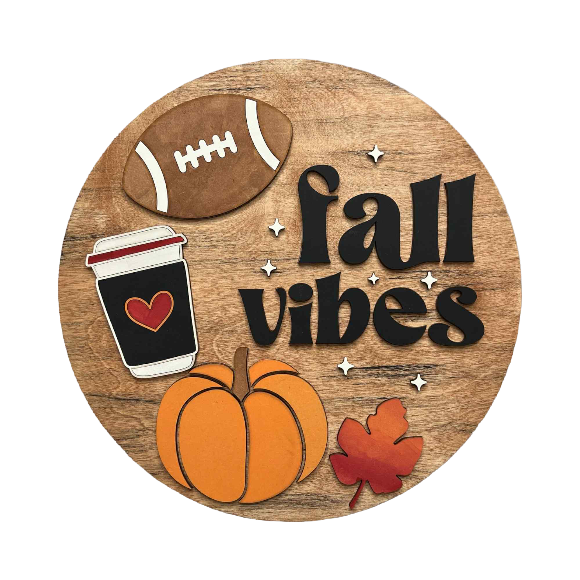 A circular wooden sign with a rustic wood-grain background featuring the words 'fall vibes' in black script, decorated with layered autumn-themed cutouts including a brown football, a black coffee cup with a red heart, an orange pumpkin, and a red maple leaf, available in San Antonio TX at DIY Sign Party.