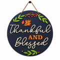 Round hanging wooden sign with a dark navy background and natural wood lettering that reads 'Thankful AND Blessed.' Decorative autumn leaves and berry branches decorate the top and bottom, and the sign hangs from a rope against a plain white background. Available at DIY Mobile Paint Party in San Antonio Texas.
