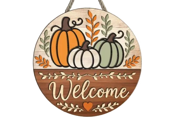 Round autumn-themed wooden hanging sign with three pumpkins, leaves, and the word 'Welcome' in script, laser cut wood surface. 